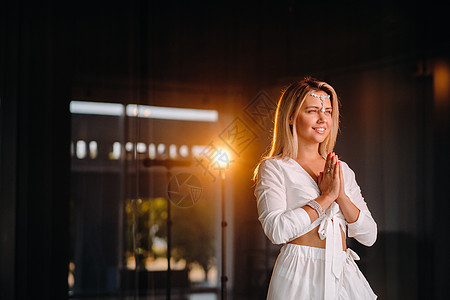 一个微笑着的女孩的肖像 穿着白色礼服 手掌在她面前瑜伽健身房教练前额姿势工作室演员舞蹈冥想天赋图片
