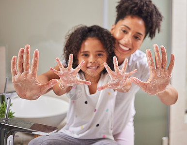 一位妈妈教孩子洗手 在浴室里用肥皂和水消灭细菌以保持健康 孩子洗脏手 保护家人健康 防止危险细菌图片