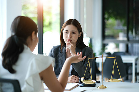 女商务人士和律师在办公室的木桌上讨论带有黄铜秤的合同文件 法律 法律服务 咨询 正义概念女士经理刑事男性协议男人起诉立法者欺凌立图片