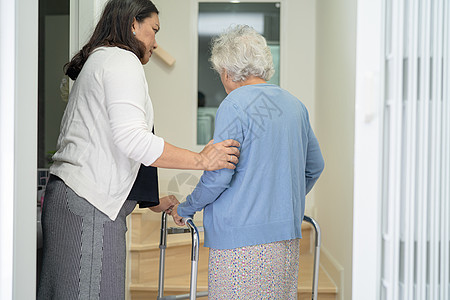 护理员帮助年老或年老的老年妇女在家中楼梯上行走时配有助行器助手女性医院服务脚步日常生活护理地面护士长老图片