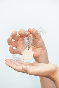 白色背景特检上的手持房屋钥匙 - 真实状态移动搬迁概念; 在白色背景上剪接图片