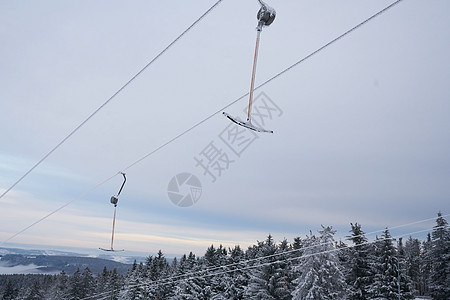 在德国黑森州雷恩的山壮丽的冬季景观背景下 滑雪缆车的一部分 神奇的高大苍松和雪杉覆盖着冰雪 地平线创造了一种幻觉 并与多云的天空图片