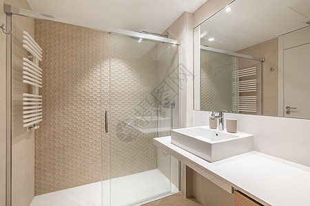 现代瓷砖洗手间内有繁多的室内 有白色水槽 大镜子和淋浴区图片