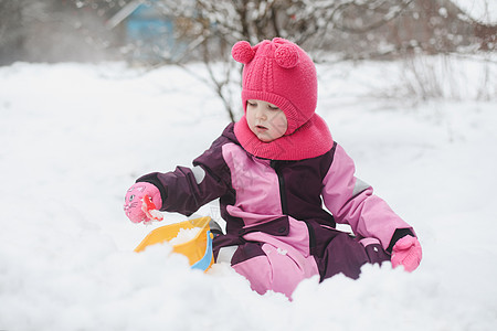 可爱的女孩在操场上用铲子和大桶挖雪 在冬季户外玩耍的小女孩家庭婴儿童年小姑娘假期幸福乐趣天气闲暇活动图片