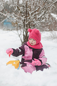 可爱的女孩在操场上用铲子和大桶挖雪 在冬季户外玩耍的小女孩幸福婴儿女性手套乐趣降雪小姑娘童年假期衣服图片