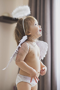 有翅膀和光环的可爱女婴 热情地仰望着高清图片