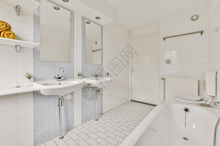 一个有两个水池和一个浴缸的白色洗手间浴室奢华公寓水龙头洗澡地面木头家具镜子桌子图片