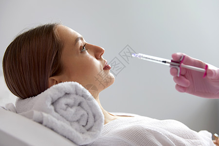 医生美容师的侧视图使年轻漂亮的女性面部皮肤恢复活力的面部注射程序收紧和平滑皱纹药品治疗美丽女孩护理皮肤科手术温泉沙龙塑料图片