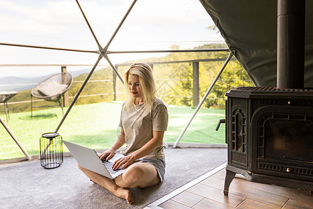 中年妇女在假期使用笔记本电脑在 Glamping 屋休息和消磨时间 假日圆顶帐篷 舒适 露营 hygge 生活方式概念商业视频庆图片