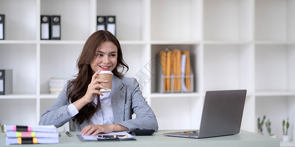 在办公室的笔记本电脑上工作的年轻女子 亚洲女商务人士坐在她办公室的工作场所 美丽的自由职业者女性在她家在线工作微笑女士生意人就业图片