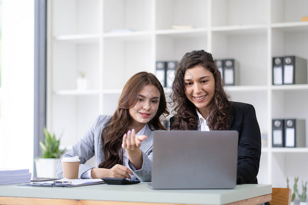 两位年轻的亚洲女商务人士在办公室交谈 咨询 讨论与新创业项目创意演示的合作分析计划营销和投资职员面试公司女士女孩工人电脑职业商务图片