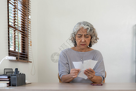 担心金融经济危机问题的高级女性 压力大的亚洲老年男性在家里用计算器和笔记本电脑计算家庭预算 债务 每月开支女士压力破产收据银行桌图片