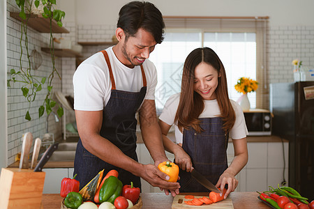 家里做沙拉的年轻亚洲夫妇肖像 烹饪食物 生活方式时刻和健康 笑声乐趣母亲午餐厨师家庭男人微笑女孩平底锅房子图片