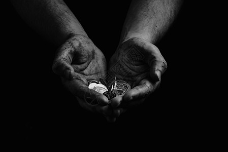 黑人和白人 一个用硬币持有乌克兰格里夫尼亚的贫穷无家可归的穷人的肮脏手掌图片