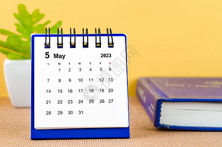 2023年5月的月度案头日历 上面有一本黄色背景的书图片