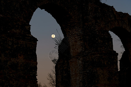 背面有满月的石形拱门日落宗教隧道精神月光月亮月球考古学阴影全景图片