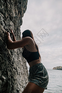 身体瘦弱的年轻女子c C级女运动员冒险绳索齿轮悬崖登山者女士活动攀岩者风险专注图片