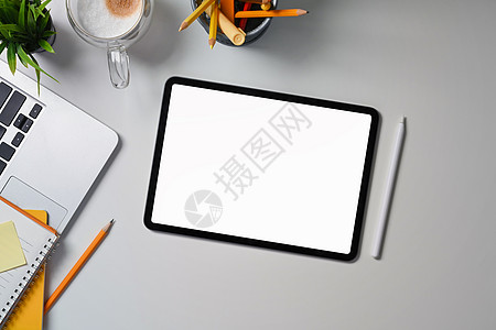 白色办公桌顶端视图数码平板电脑 钢笔 膝上型计算机和文具图片