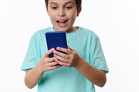 有选择地关注一个可爱的小男孩手中的手机 他在使用智能手机时表示惊讶图片