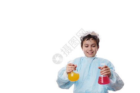 年轻化学家 -聪明的学龄前男生 穿着实验室大衣 在化学课上把化学试剂倒进玻璃蒸馏器里图片