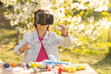 青少年玩家女孩戴着虚拟现实眼镜和耳机体验幻想世界 戴着虚拟眼镜的带复活节彩蛋的少女互联网技术粉色视频风镜游戏孩子头盔齿轮娱乐图片