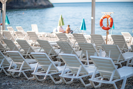 几个白太阳休息员和一只雨伞 在荒凉的海滩上 完美的假期概念躺椅天堂海岸热带闲暇海洋旅行海岸线蓝色退休图片