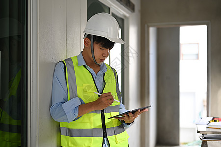 使用数字平板电脑 检查建筑施工进度的亚洲男性安全头盔男工程师图片