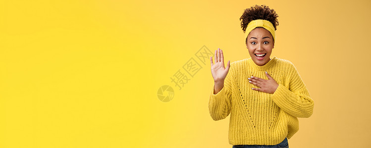 迷人而有趣的年轻迷人 真诚的非洲裔美国女孩头带毛衣按压手胸举起手掌发誓承诺尽她最大的努力站立兴奋地笑着 摆出黄色背景大学女性互联图片