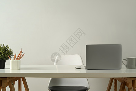 科技电脑现代家庭办公室内部 膝上型计算机 铅笔持有器 咖啡杯和白色桌上的陶工厂背景