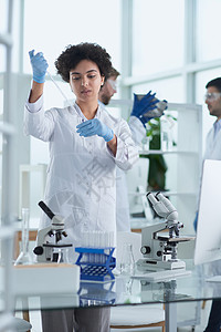 研究科学家微笑地看着实验室中穿过的照相手手臂生物学眼镜男性疾病保健药品成人化学品生物男人背景