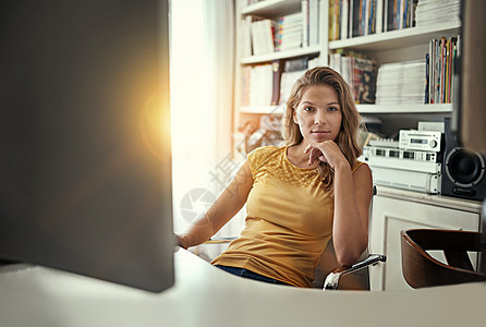 年度企业家 一位年轻女子在她家庭办公室的电脑前工作的画像图片