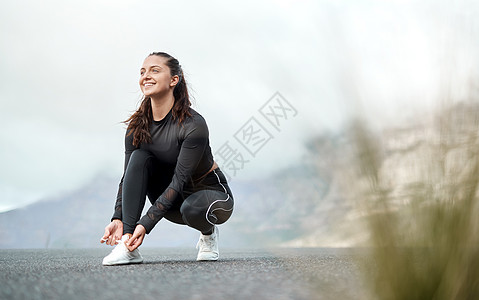 我不能选择一个更好的早晨来跑步 一个迷人的年轻女人在独自在户外锻炼之前系鞋带的全长镜头背景图片