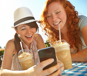 多有趣的文字 两个少女在用手机发短信时 享受着冰淇淋的滋味图片