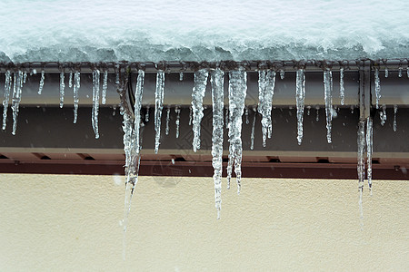屋顶边缘挂着许多冰柱的冰柱图片