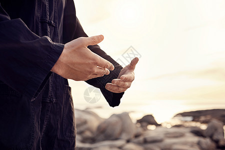 太极拳手或在海滩 大海或海洋中冥想以获得心态健康 禅宗或健身运动健康 日落时的变焦 武术或男子进行脉轮训练 和平锻炼或空手道锻炼背景图片