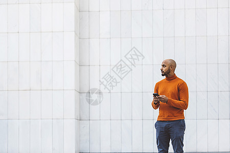 一个人在办公大楼外面拿着电话 站着手机机动性城市街道技术商业环境思维商务金融图片