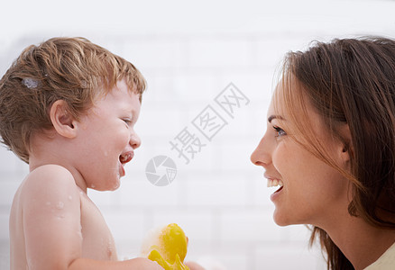 洗澡时间 一个小男孩在和母亲洗澡时拿着橡皮鸭图片