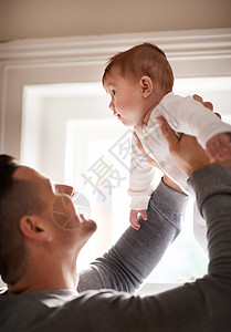 婴儿充斥着你心中的一席之地 你永远不知道是空的 一个年轻父亲抱起他可爱的女婴图片