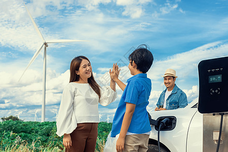 在风力农场用电动车逐渐实现幸福家庭的概念发电机父亲涡轮活力充电器生态环境力量涡轮机父母图片