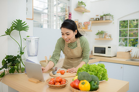 根据数字板食谱在厨房的女囚饮食食谱闲暇技术女性女士烹饪药片沙拉蔬菜图片