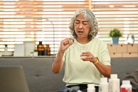 拥有避孕药和水杯的中年妇女 老年人保健 医药治疗概念 第12条白发福利处方老年女性疾病诊断制药客厅医疗保险图片