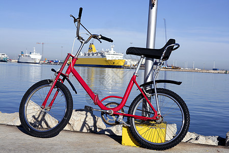 在蓝色水面上停在港口的自行车图片
