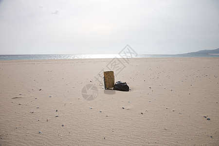 海滩上的木粉垃圾桶和塑料袋图片