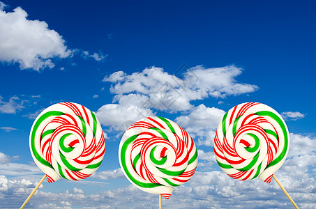 sk 背景中白色绿色和红色的三个糖棒棒糖图片