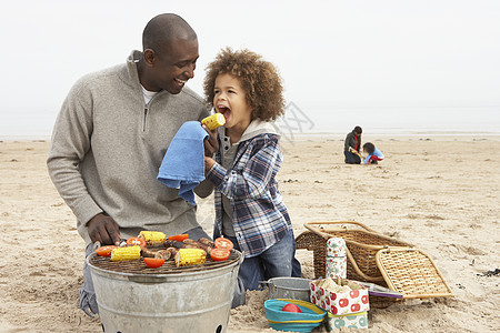 年轻家庭享受海滩上的烤肉 父母 放松 7岁 假期图片