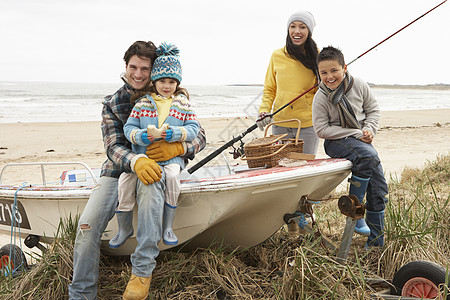 家庭小组在冬季海滩与钓鱼 Rod号船上坐船 笑声 父亲图片