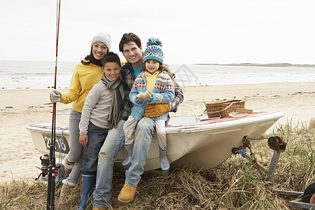 家庭小组在冬季海滩与钓鱼 Rod号船上坐船 三十多岁 7岁图片
