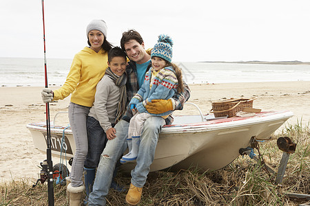 家庭小组在冬季海滩与钓鱼 Rod号船上坐船 杆 四个人图片