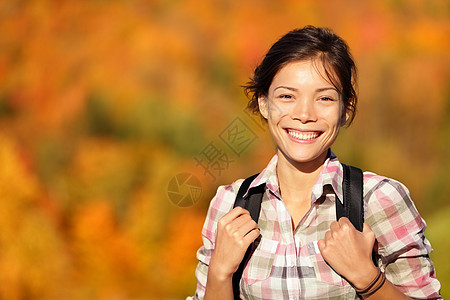 亚洲妇女徒步旅行者在秋季森林远足图片