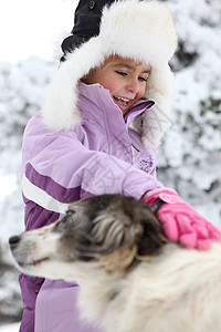 小女孩在雪中宠小狗图片